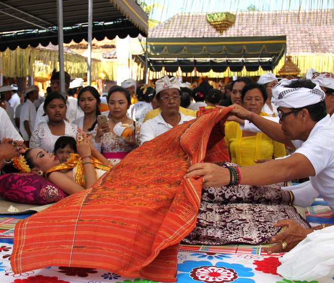 Cepuk being laid on a girl undergoing toothfiling, Ubud, Bali, July 2016