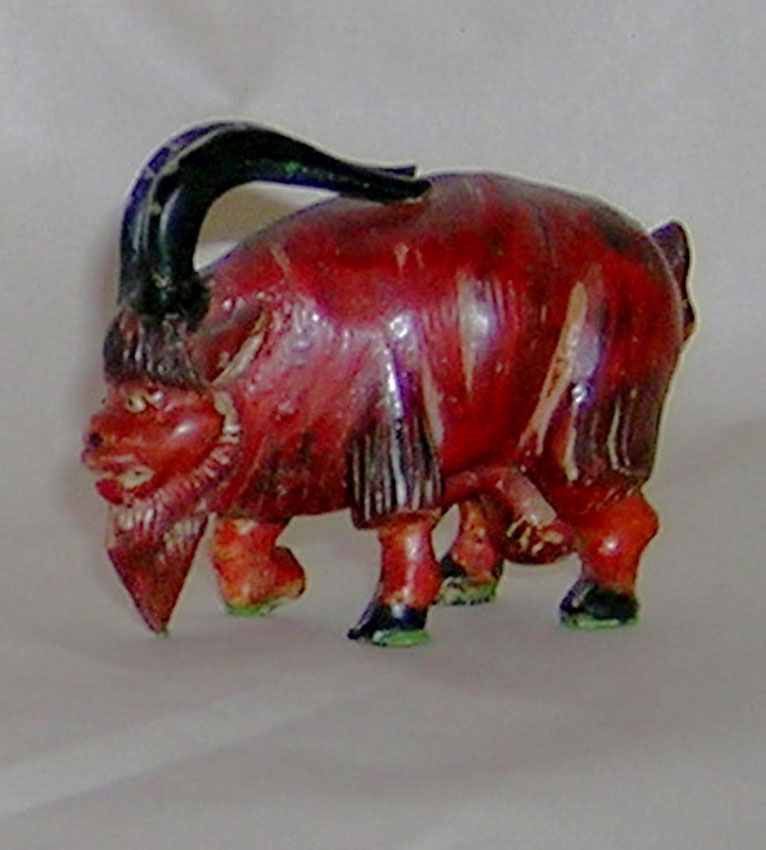 A carved wooden image of a ram