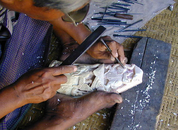 Rough carving on a large piece using a wide chisel and tapper.