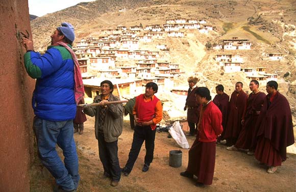 John Sanday, assisted by Tibetan workers, places tell-tales in the exterior wall of Palpung to monitor movement of a crack.

