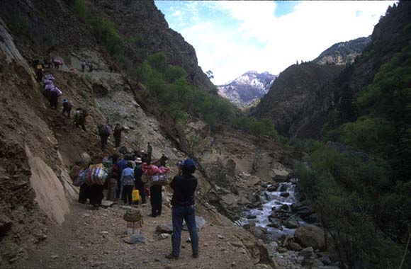 Damage to a trail means that the expedition equipment must be carried up this hill of dirt to where the horses are waiting to take the team to Baiya.