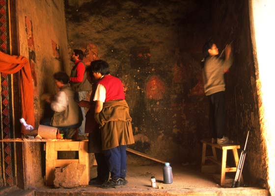 Conservation experts and apprentices clean murals at the entrance to Baiya.