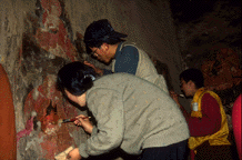 Apprentices clean a mural at Baiya Monastery.