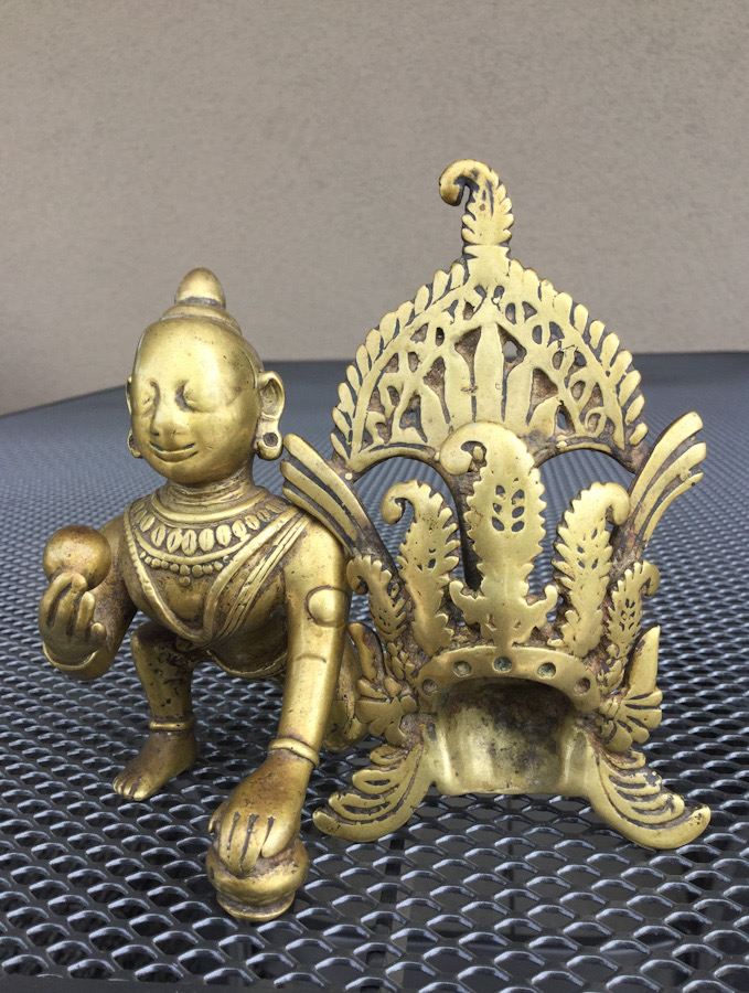 A brass figure of Gopi Krishna with his tiara