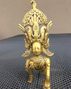 A brass figure of Gopi Krishna with his tiara