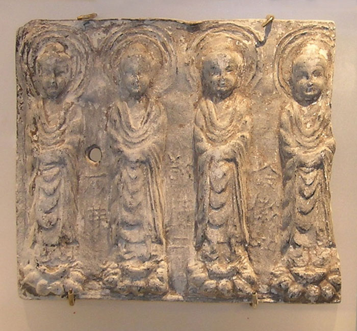 An impressed white plaque depicting standing Bodhisattvas