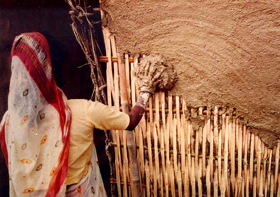 Building and shaping a wall: first, bamboo is covered with clay and dung